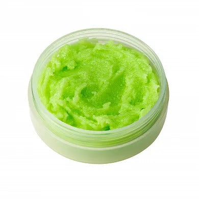 Green lip scrub with macadamia and almond oils in a clear jar, offering moisturizing and exfoliating benefits for smooth lips.